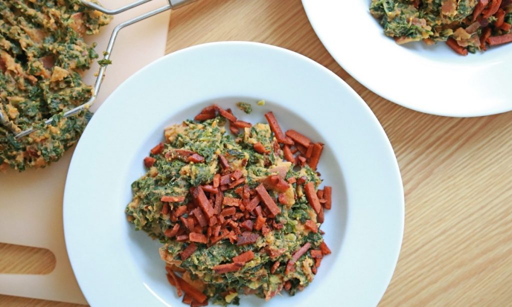 Afgewerkte boerenkool stamppot met rookworst op een bord, klaar om op te eten